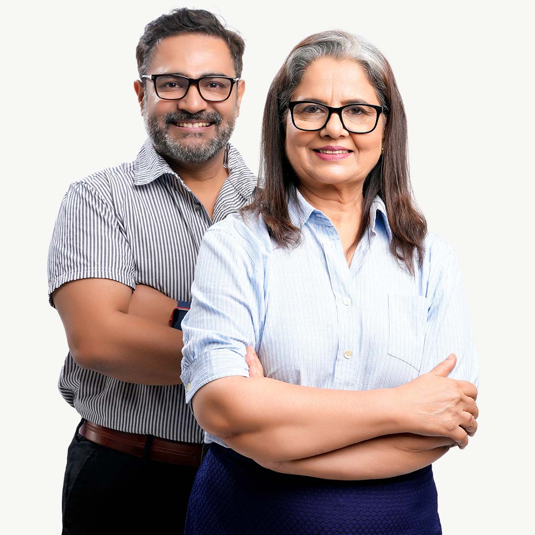 Two professionals wearing glasses pose together against a white background. The woman in front wears a light blue striped shirt and dark skirt with her arms crossed, smiling at the camera. The man behind her wears a gray striped short-sleeved shirt and dark pants with his arms crossed.