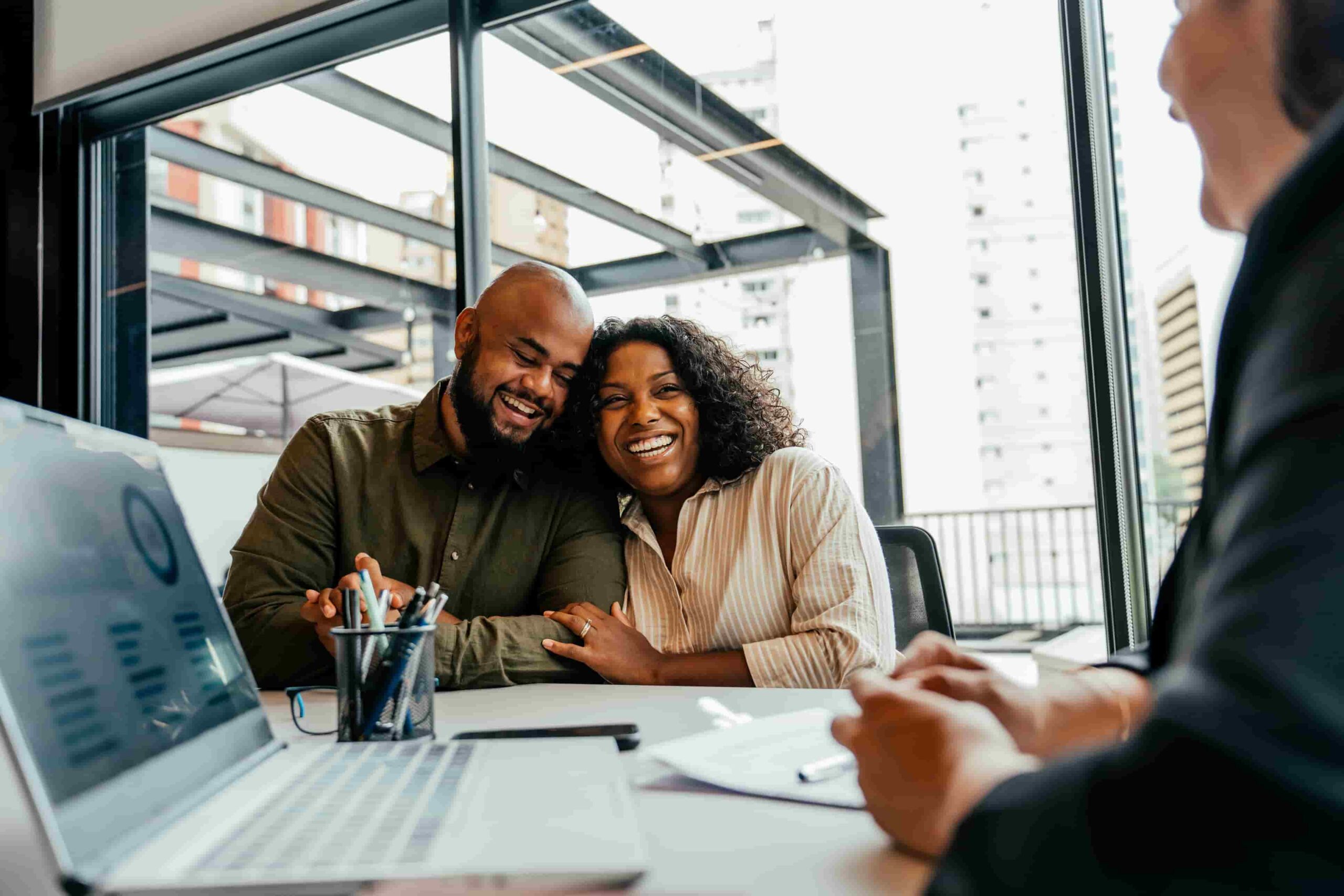 African American couple hugging in excitement in meeting with bank advisor
